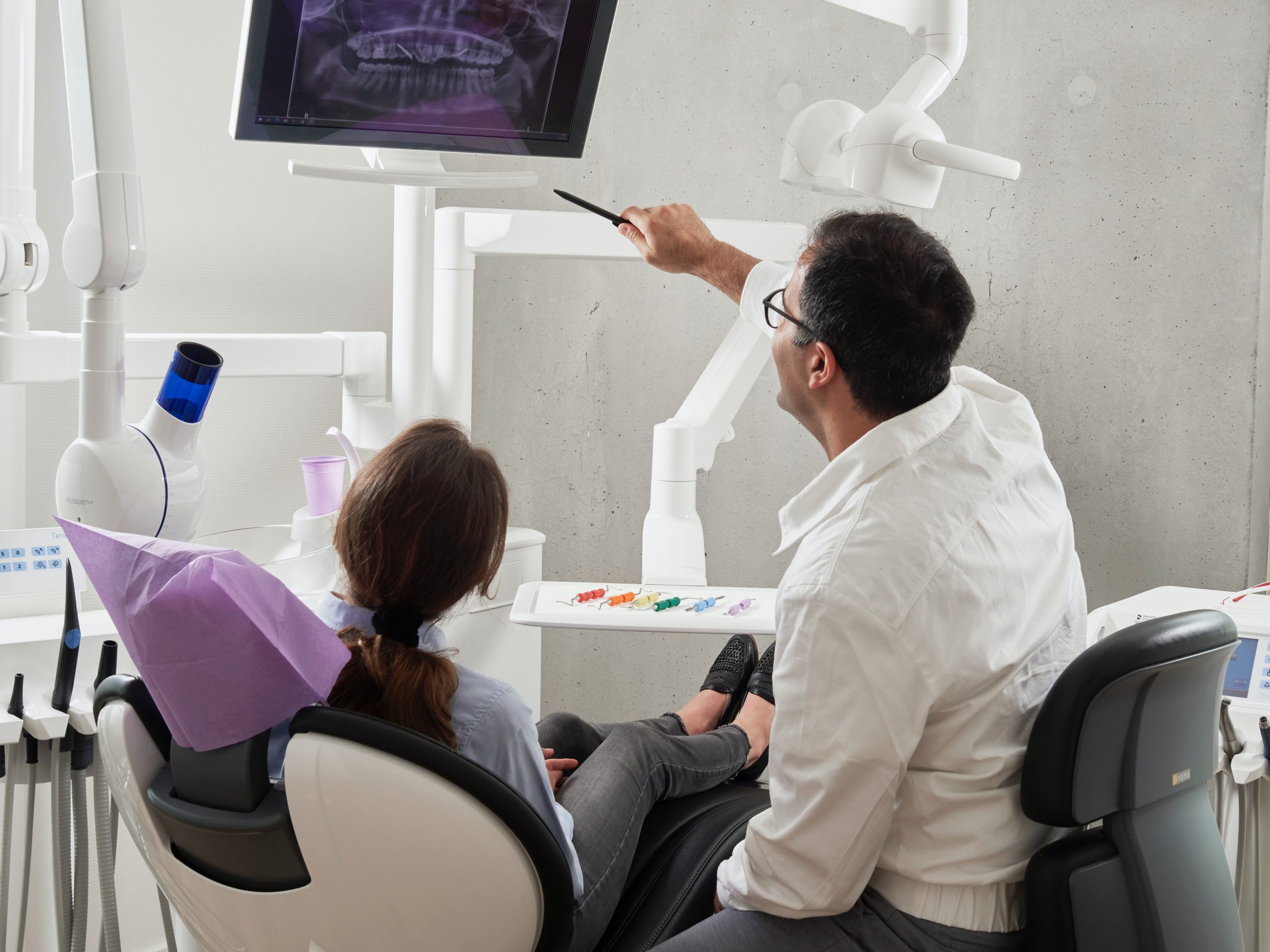 Dentist showing patient teeth x-ray